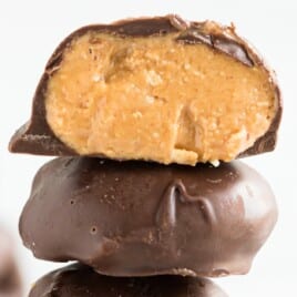 a stack of Keto Chocolate Peanut Butter Balls, the top one with a bite on it