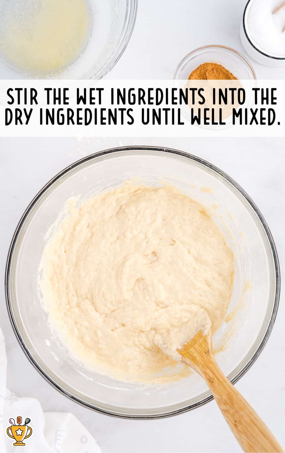 Ingredients for making Snickerdoodle Bread in a bowl with a wooden spoon