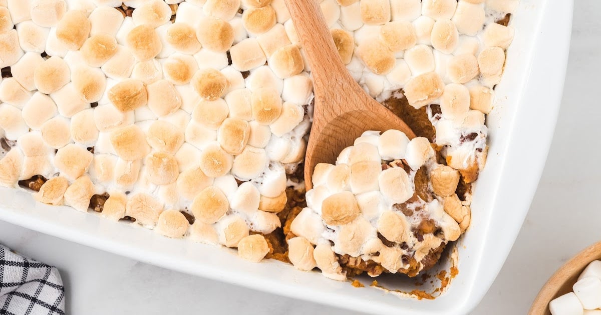 Sweet Potato Casserole in a baking tin with a wooden spoon