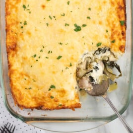 Spinach and Artichoke Chicken Casserole in a baking dish with a spoon
