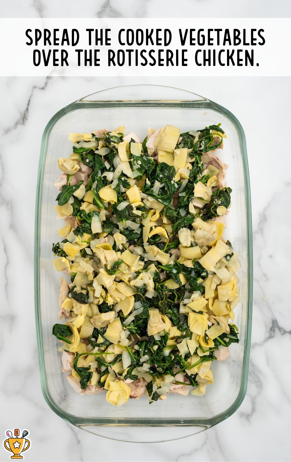cooked vegetables spread over the rotisserie chicken in a baking dish