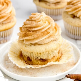 a Cinnamon Cupcake on a serving plate with a bunch others at the back