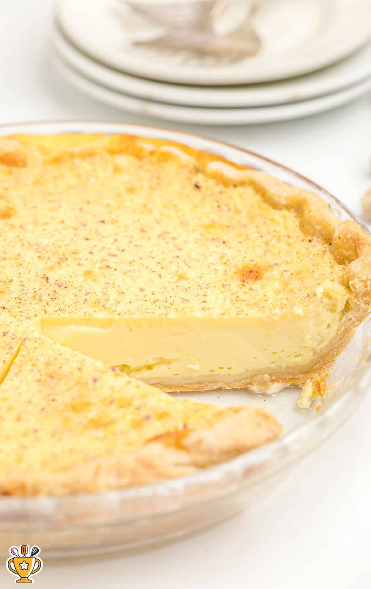 a Custard Pie in a glass pie plate with a slice missing from it.