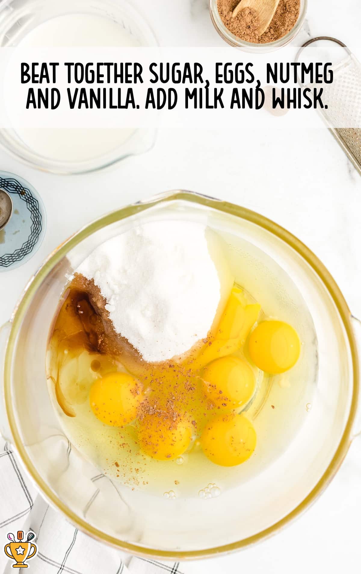 The eggs, nutmeg, vanilla and sugar are in a mixing bow.