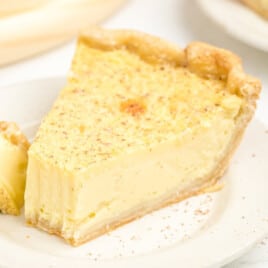 A slice of Custard Pie on a white plate with a fork.