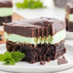 A mint chocolate brownie on a white dessert plate with a bite out of it.