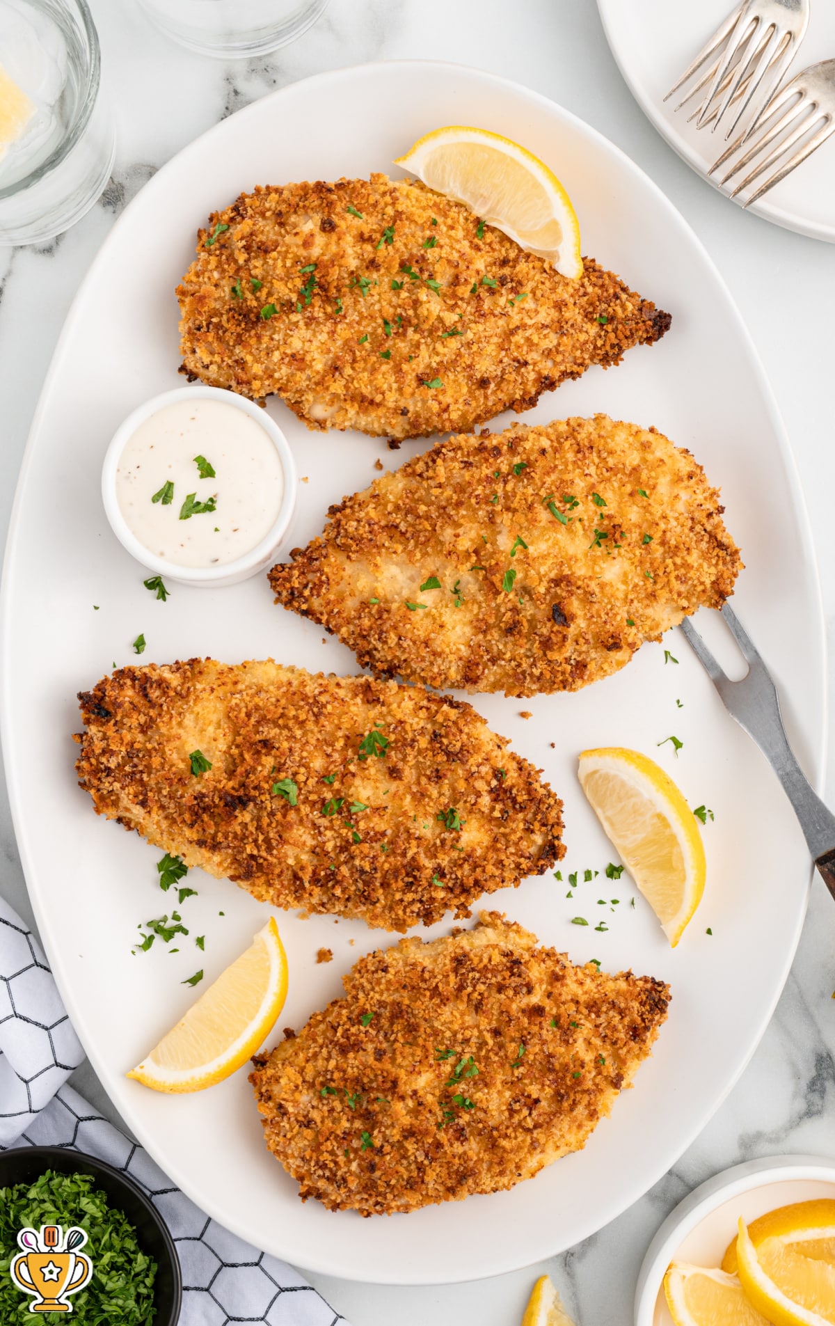 An oval plate with four pieces of panko chicken on it.