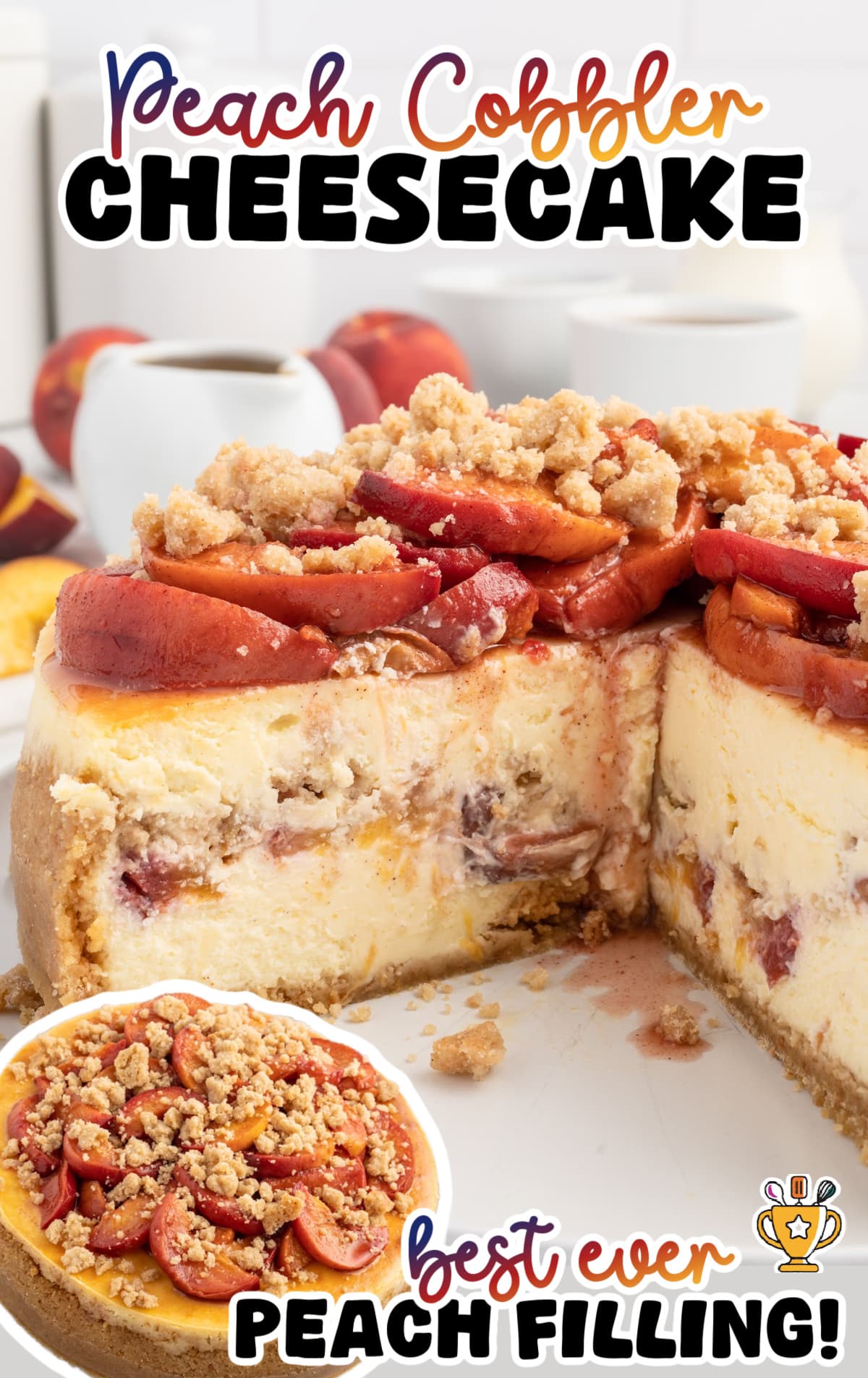 Close-up image of a peach cobbler cheesecake with a thick graham crust, creamy cheesecake layers swirled with baked peaches, and a generous topping of tender cinnamon-spiced peaches and buttery crumble. Peaches and kitchen items are blurred in the background for a bright, inviting look.