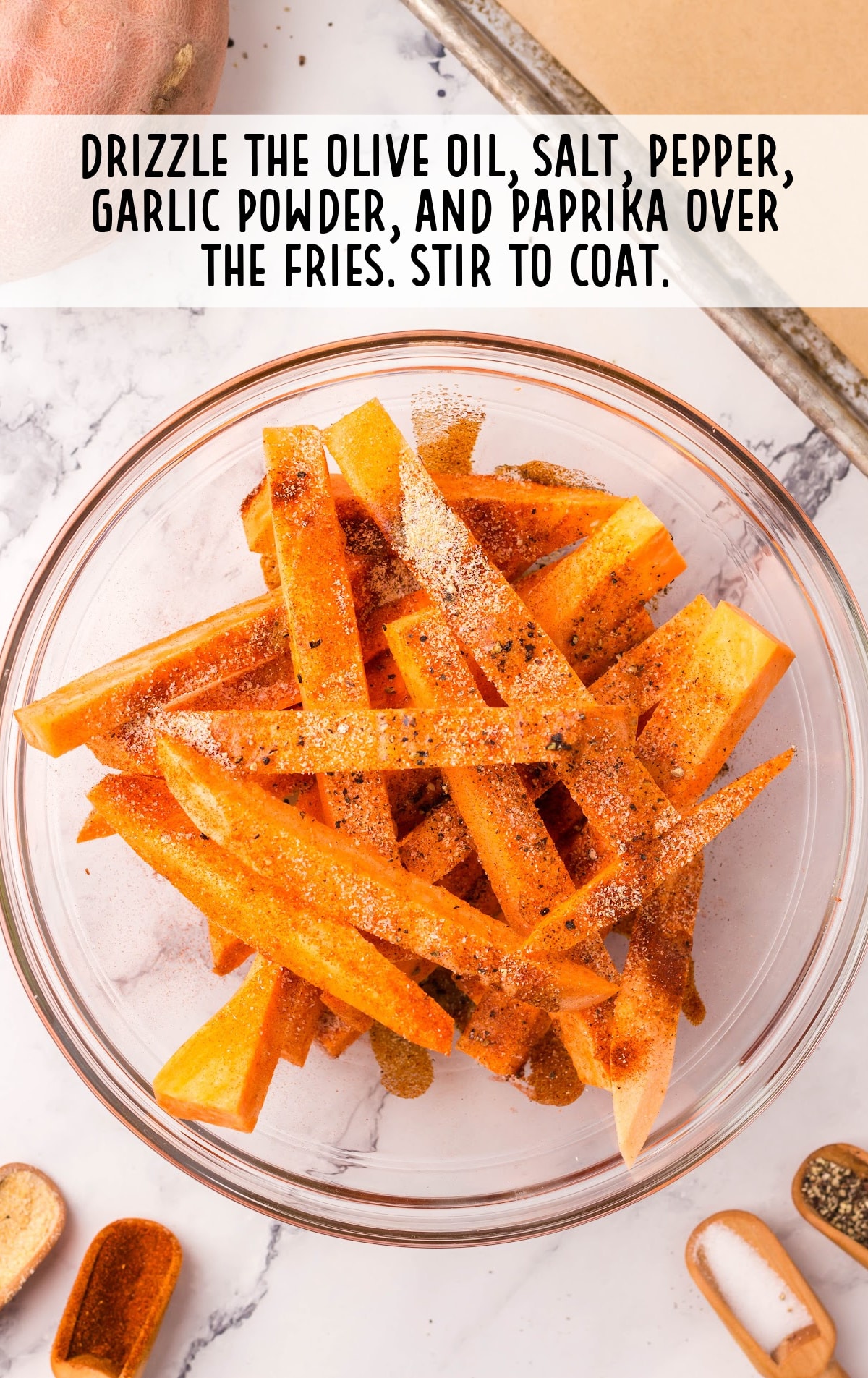 olive oil, salt, pepper, garlic powder and paprika drizzled over fries in a bowl
