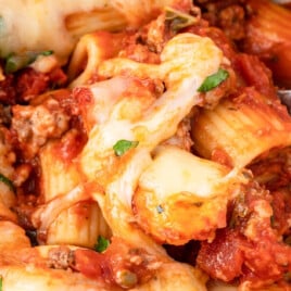 a close up photo of Baked Rigatoni with a spoon holding some of it
