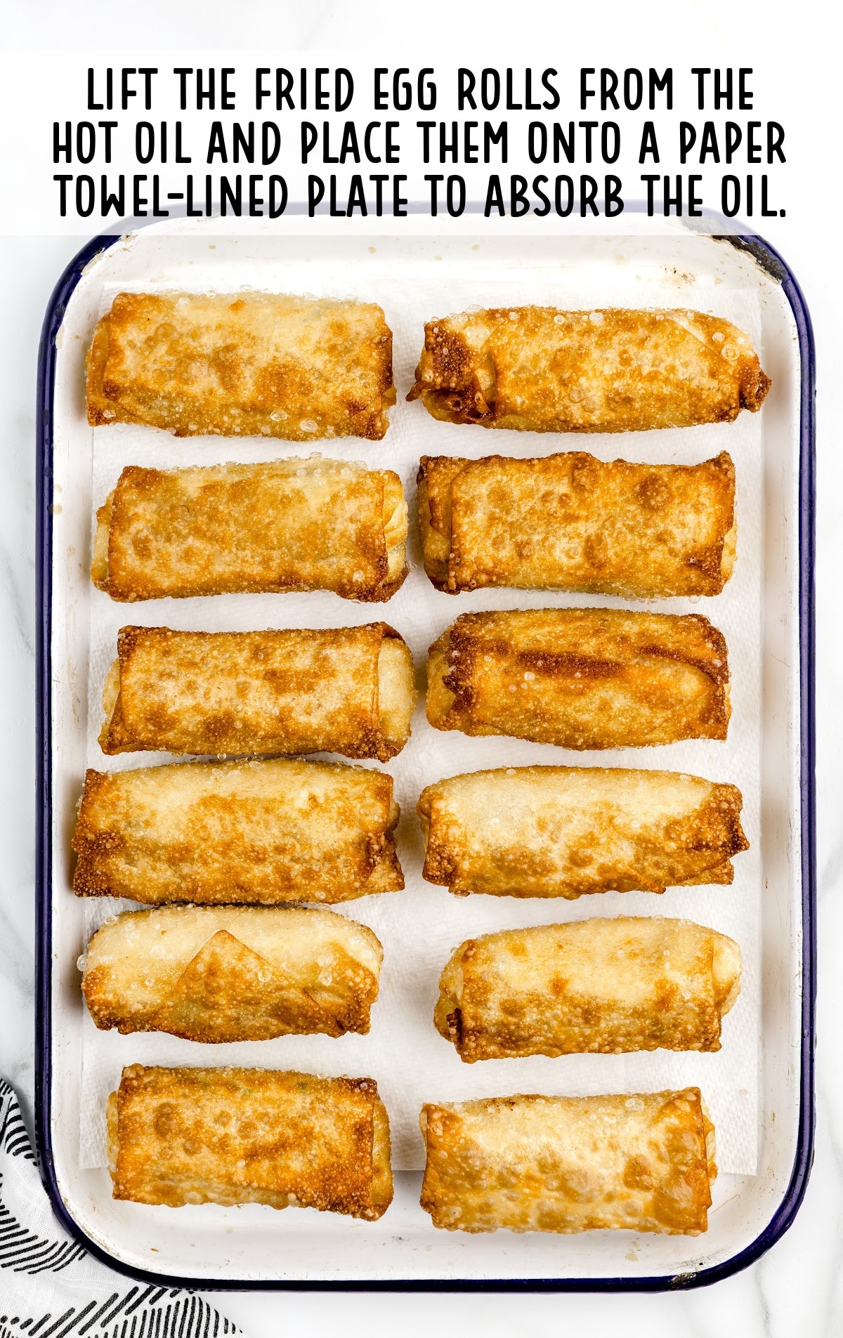 Crab Rangoon Eggroll placed on a paper towel-lined plate to absorb the oil