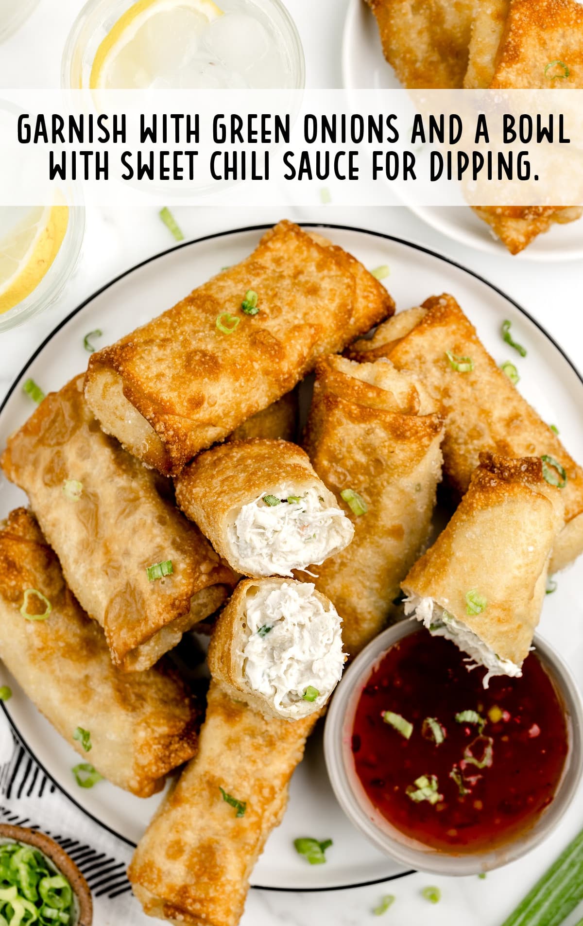Crab Rangoon Eggroll on a plate, garnished with green onions and a bowl with sweet chili sauce for dipping
