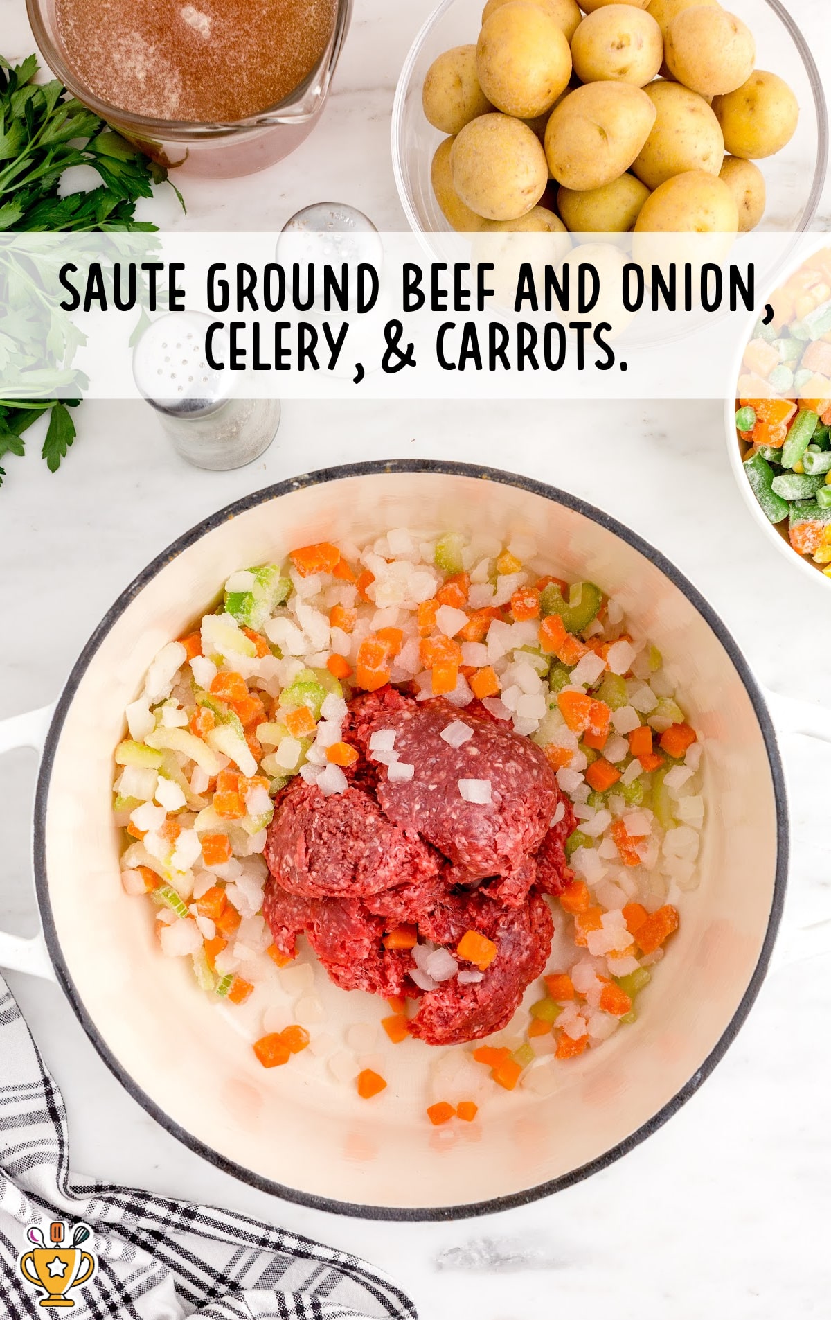 ground beef, onion, celery and carrots mixed in a bowl