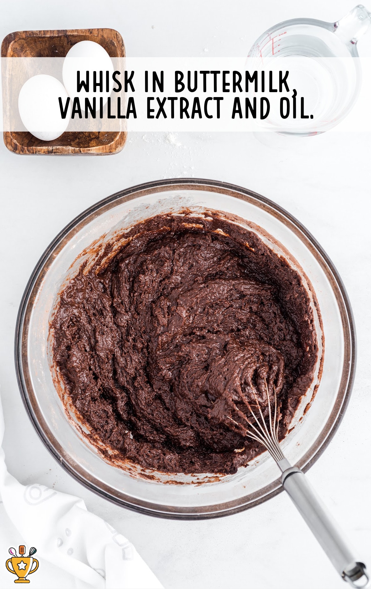 buttermilk, vanilla extract and oil added in a bowl with a whisker