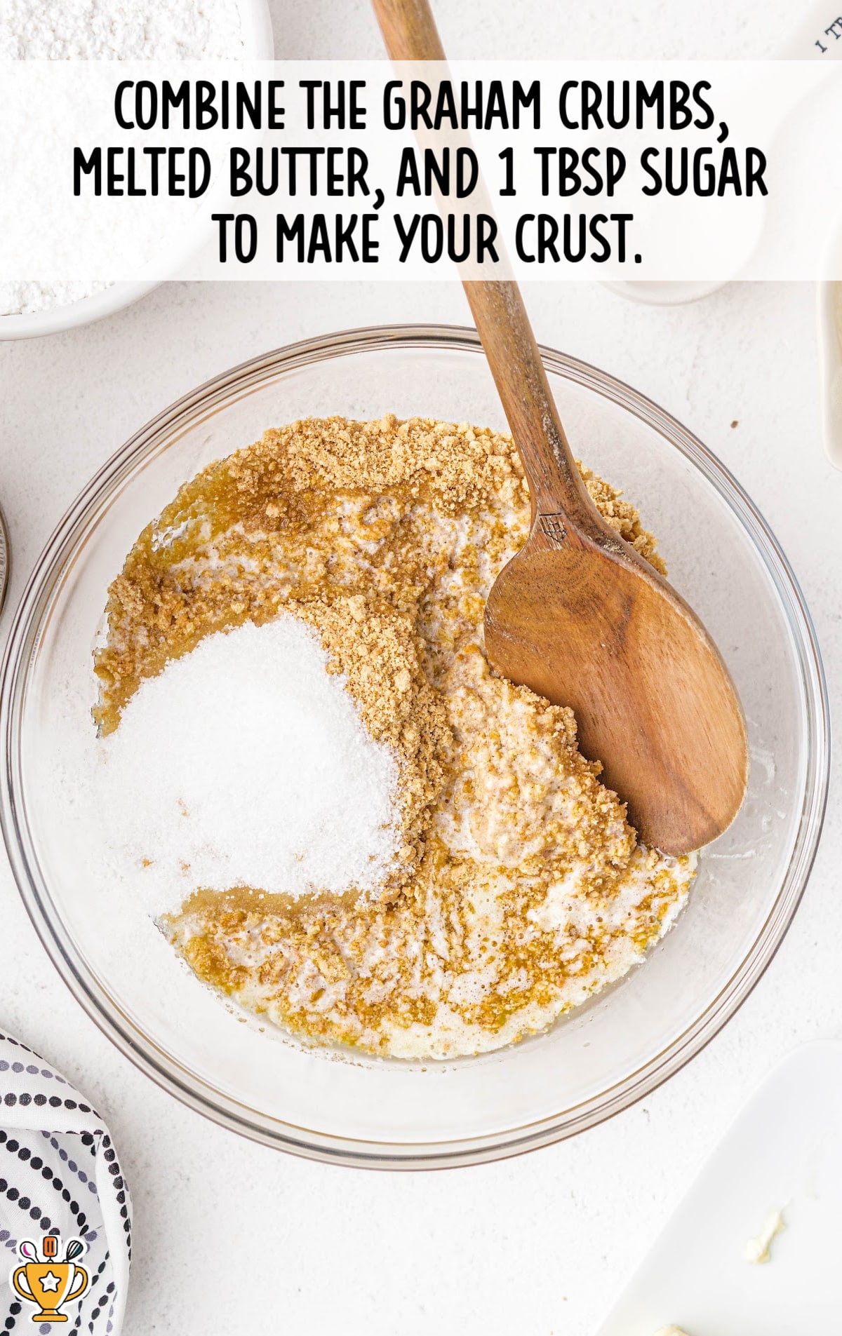 graham crumbs, melted butter and sugar combined in a bowl with a wooden spoon