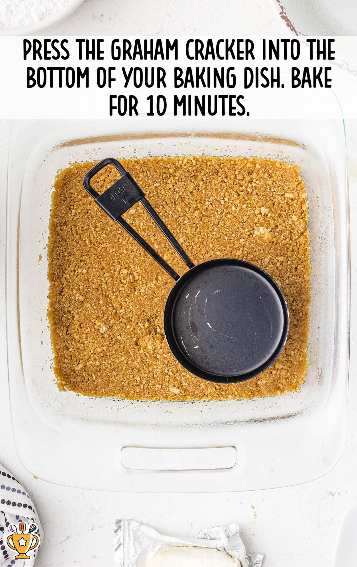 pressing graham crackers into the bottom of the baking dish, ready to bake