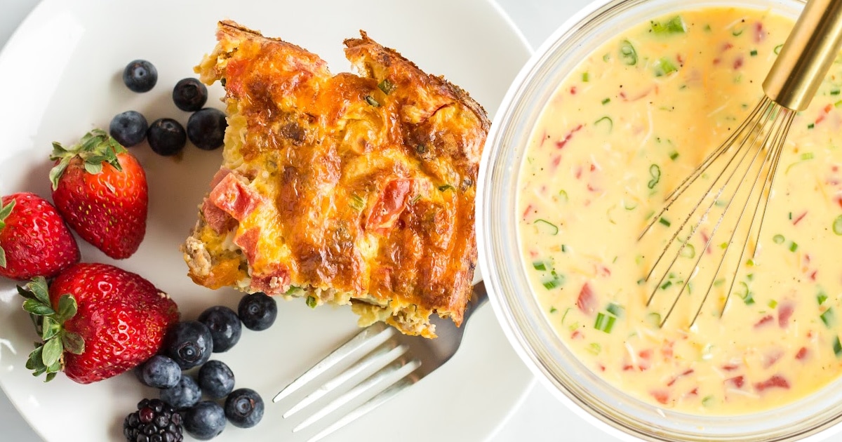 a piece of Sausage Breakfast Casserole on a plate with strawberries and blackberries and blueberries