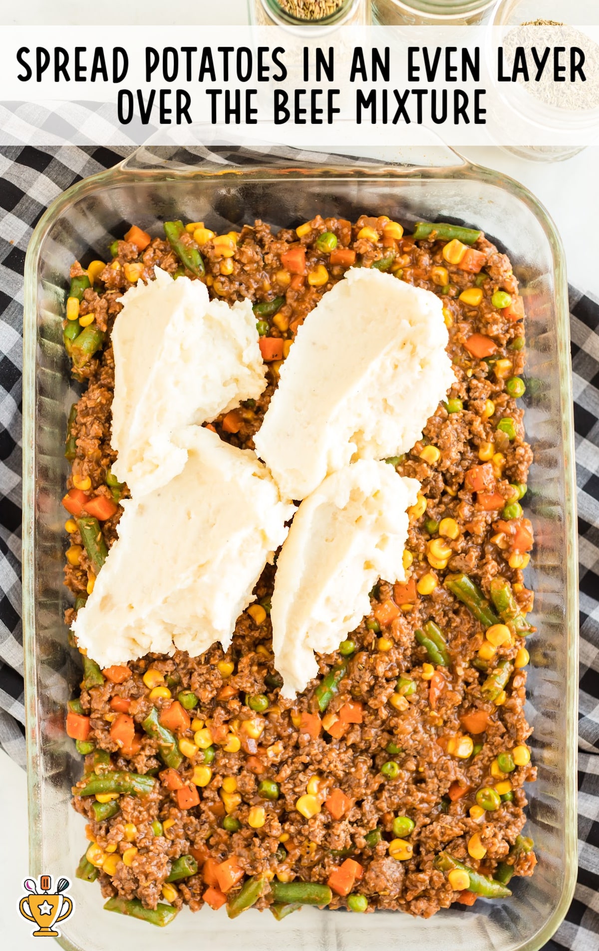 spreading potatoes in a dish over the beef mixture