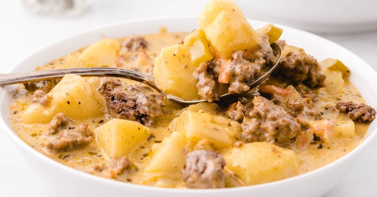 a bowl full of Cheeseburger Soup with a spoon holding some