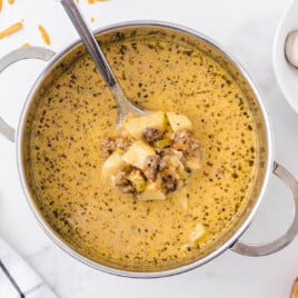Cheeseburger Soup in a pot with a serving spoon holding some of it