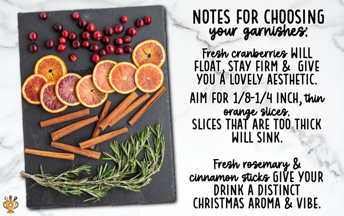 Garnish tips for a cranberry Christmas cocktail featuring thin blood orange slices, fresh cranberries, rosemary sprigs, and cinnamon sticks arranged on a slate board for festive holiday drinks.