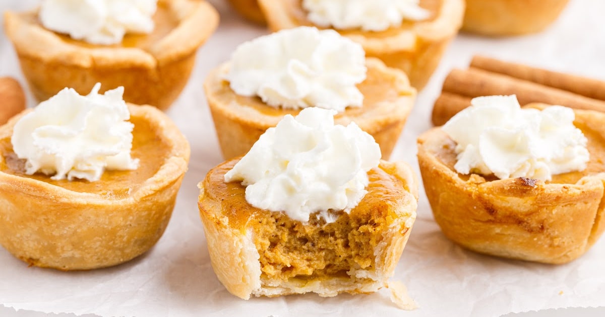 Plenty of Mini Pumpkin Pies, one with a bite on it