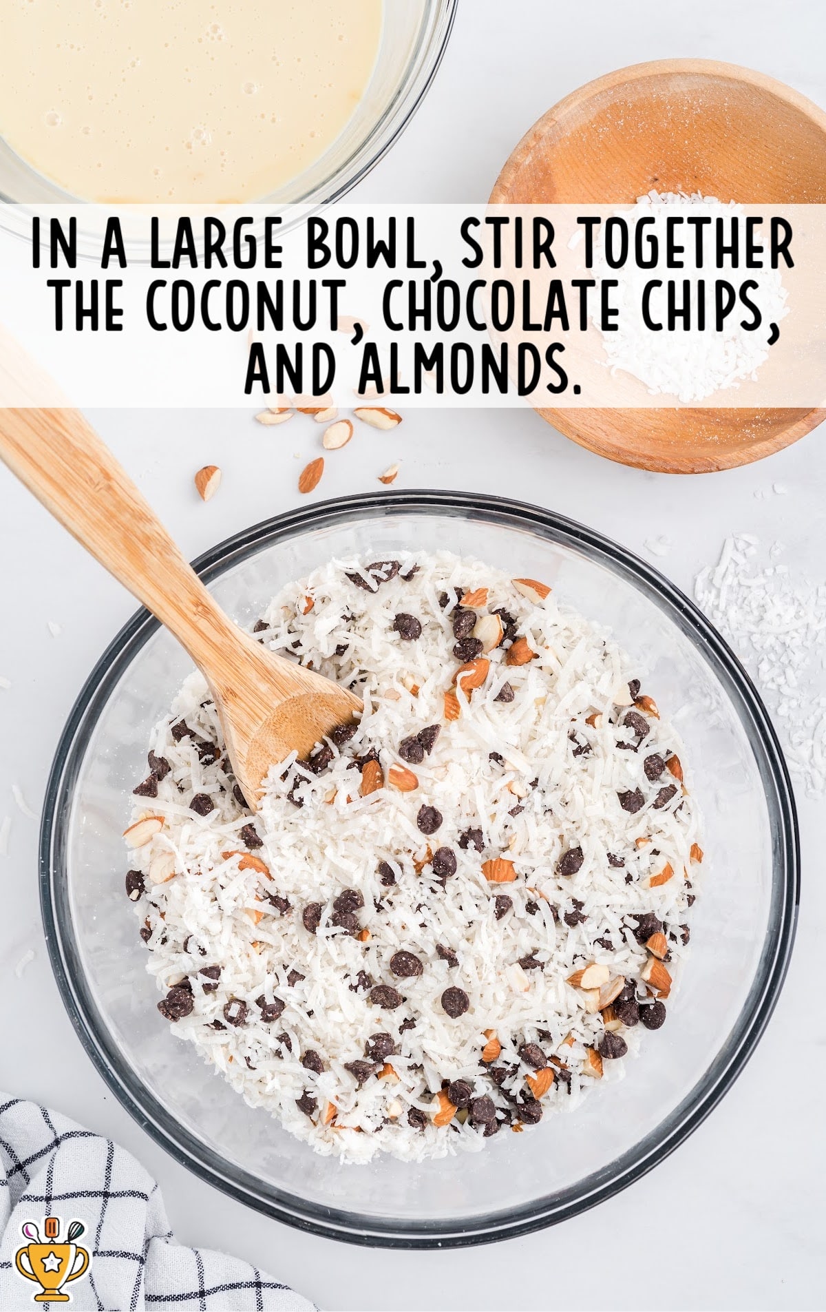 coconut, chocolate chips and almonds stirred together in a large clear bowl
