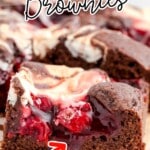 Cherry Cheesecake Brownies on a cutting board with plenty of cherries.