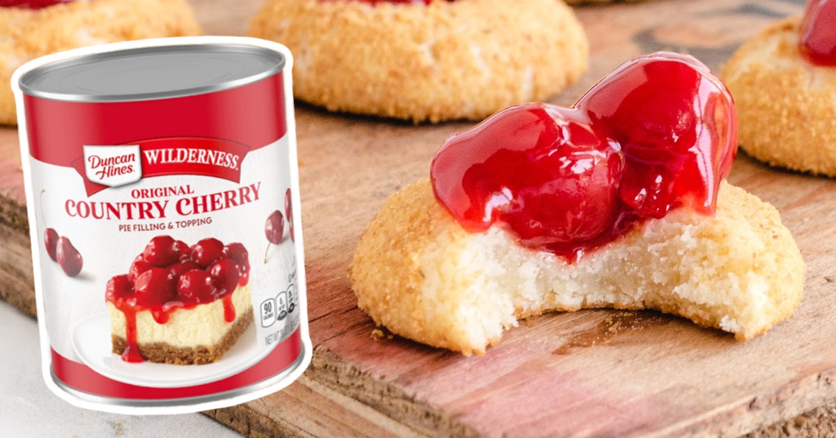 a Cherry Cheesecake Cookie with a bite on it and a bunch others at the back, with a pie filling can on the side
