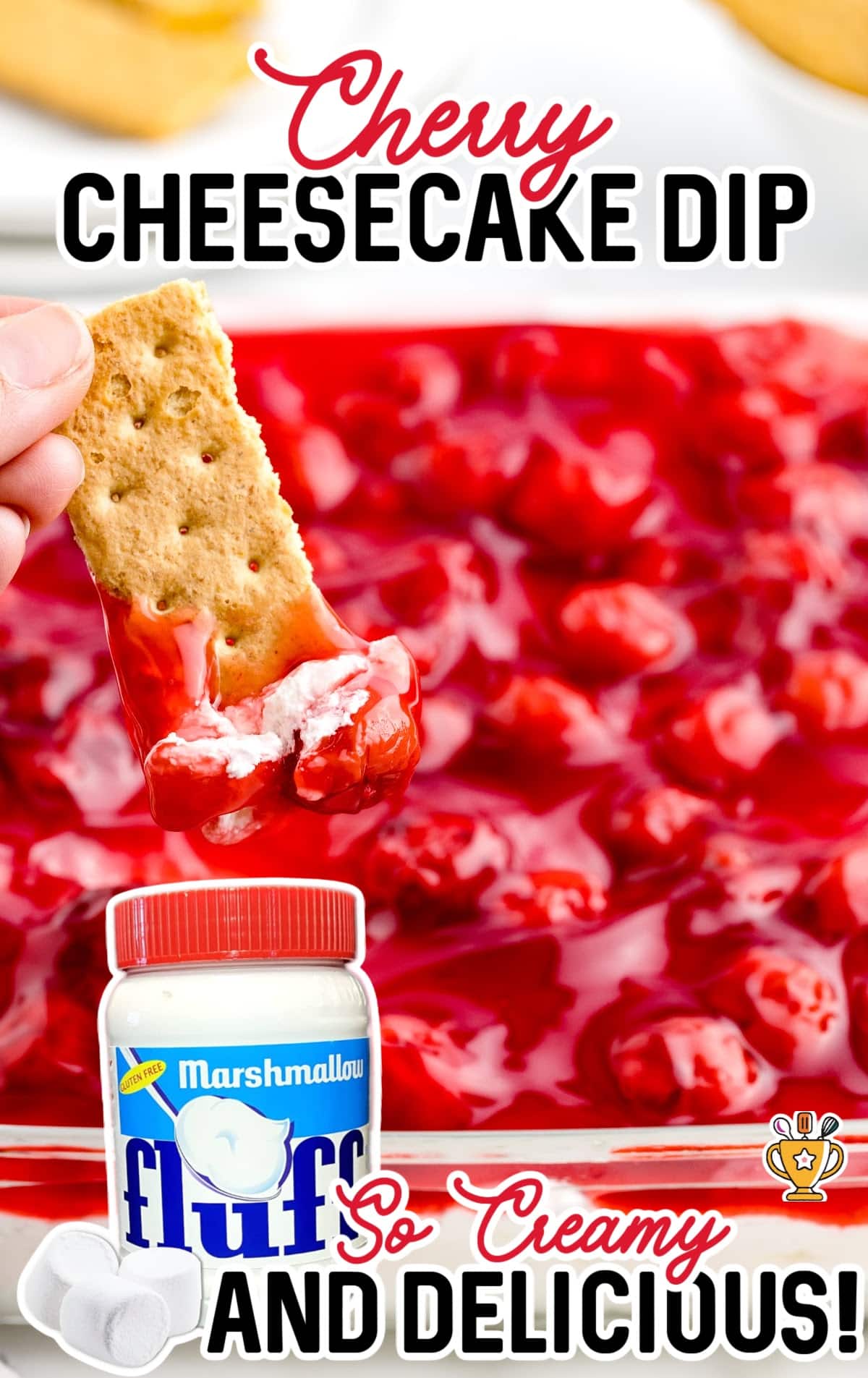 a hand holding a biscuit dipped in Cherry Cheesecake Dip