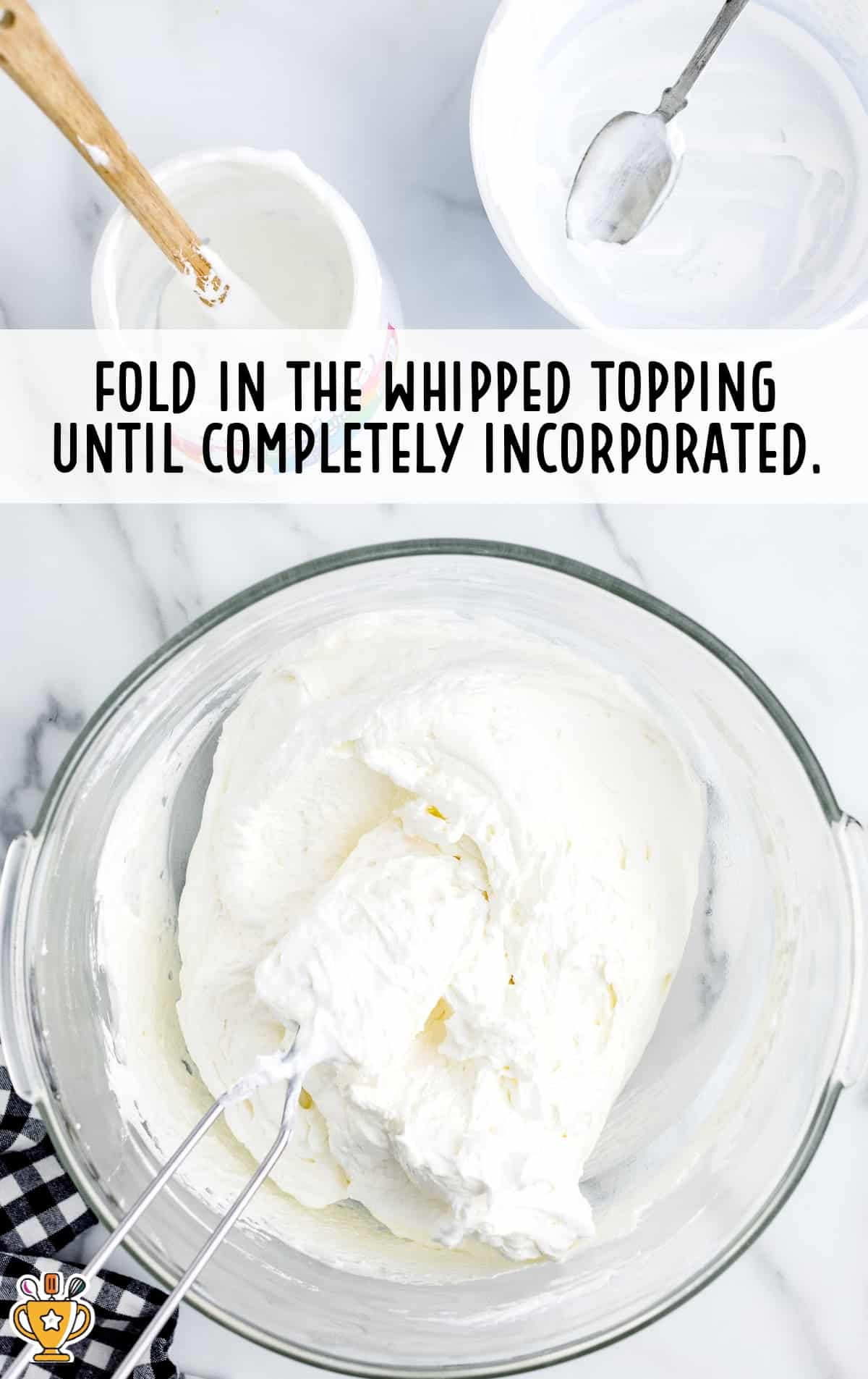 folding in whipped topping in a clear bowl