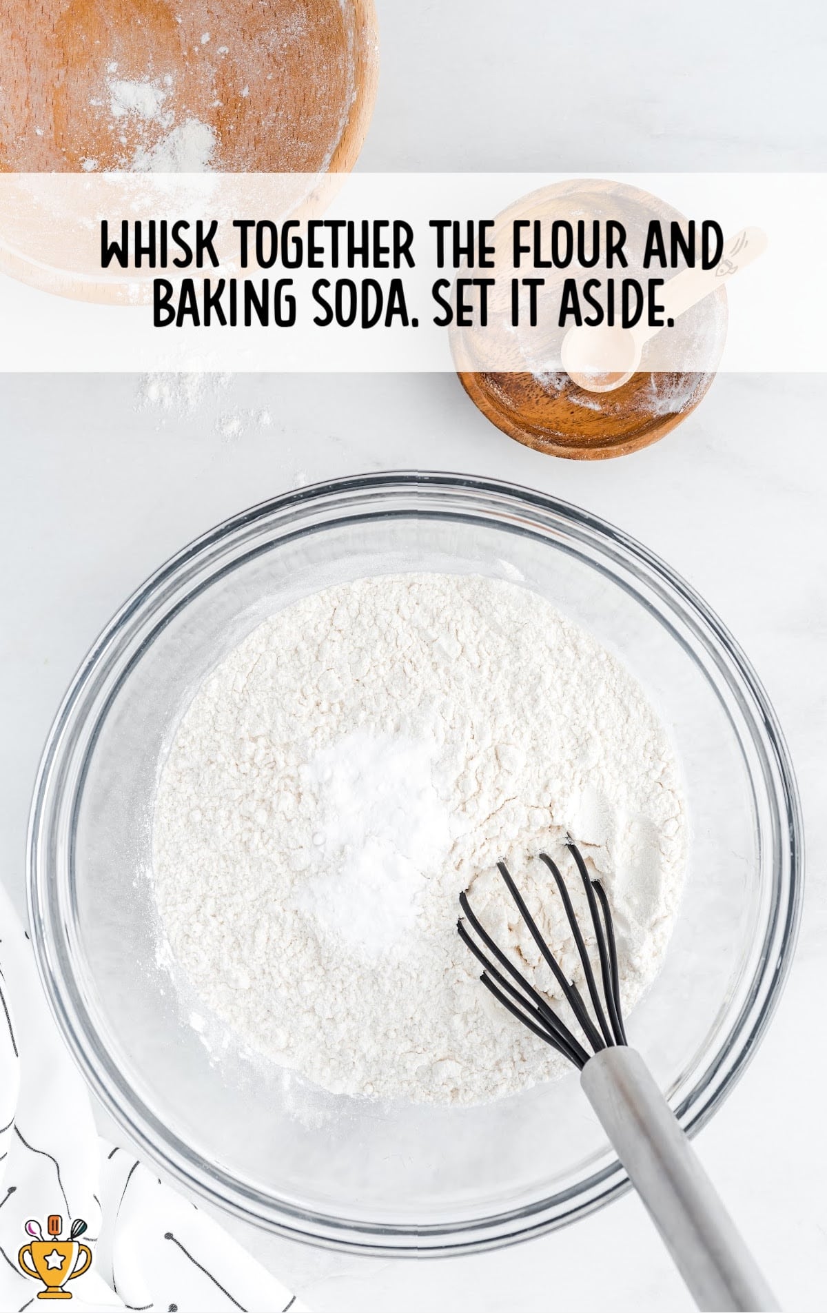 flour and baking soda added in a bowl with a whisker