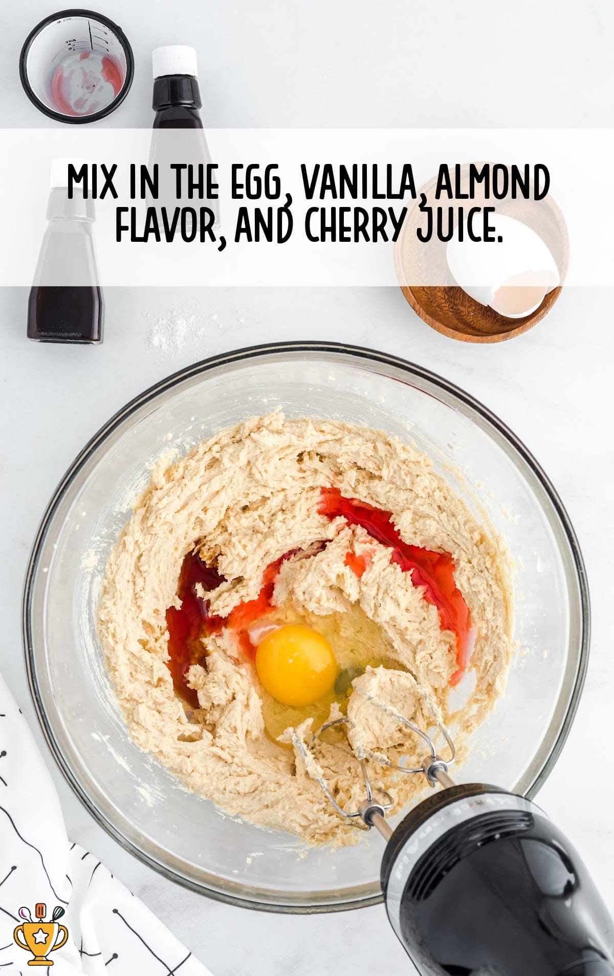 egg, vanilla, almond flavor and cherry juice mixed together in a bowl