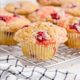 a Cherry Cobbler Muffin on a cooling rack and a bunch others at the back