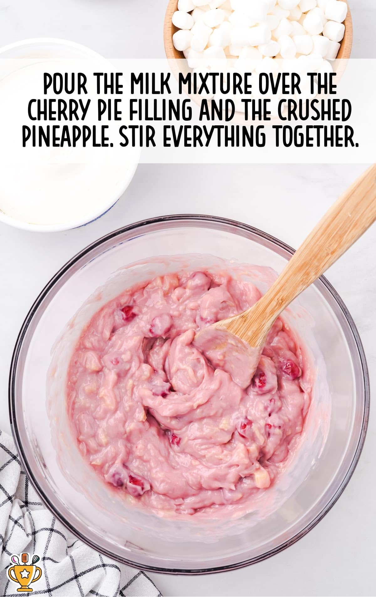 milk mixture poured over the cherry pie filling and the crushed pineapple in a bowl