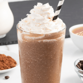 A coffee smoothie with a straw in it.