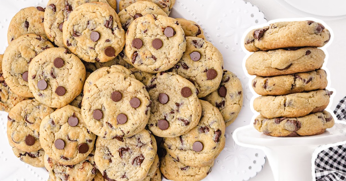 a bunch of Cream Cheese Chocolate Chip Cookies and a stack of Cream Cheese Chocolate Chip Cookies on a cake stand