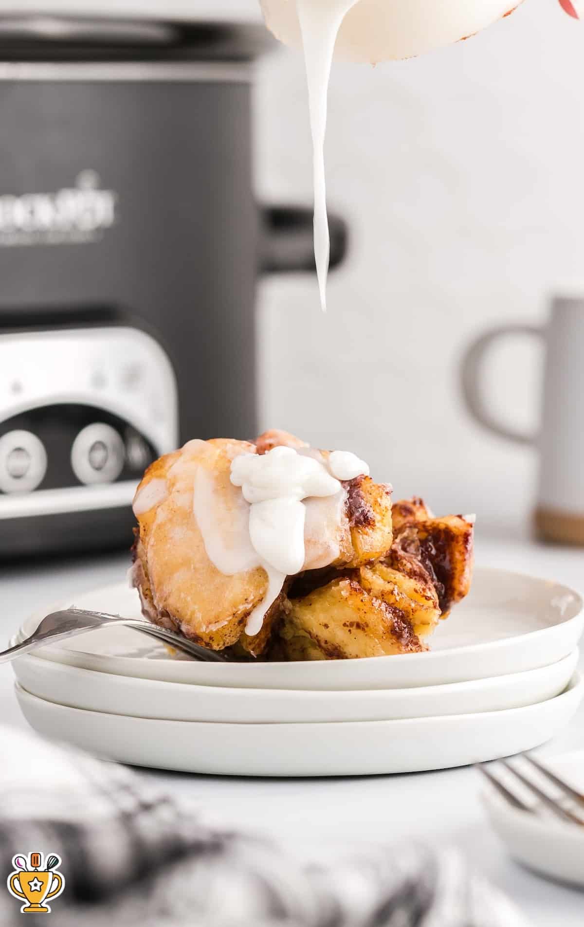 Crockpot Cinnamon Roll Casserole served on a plate with a fork