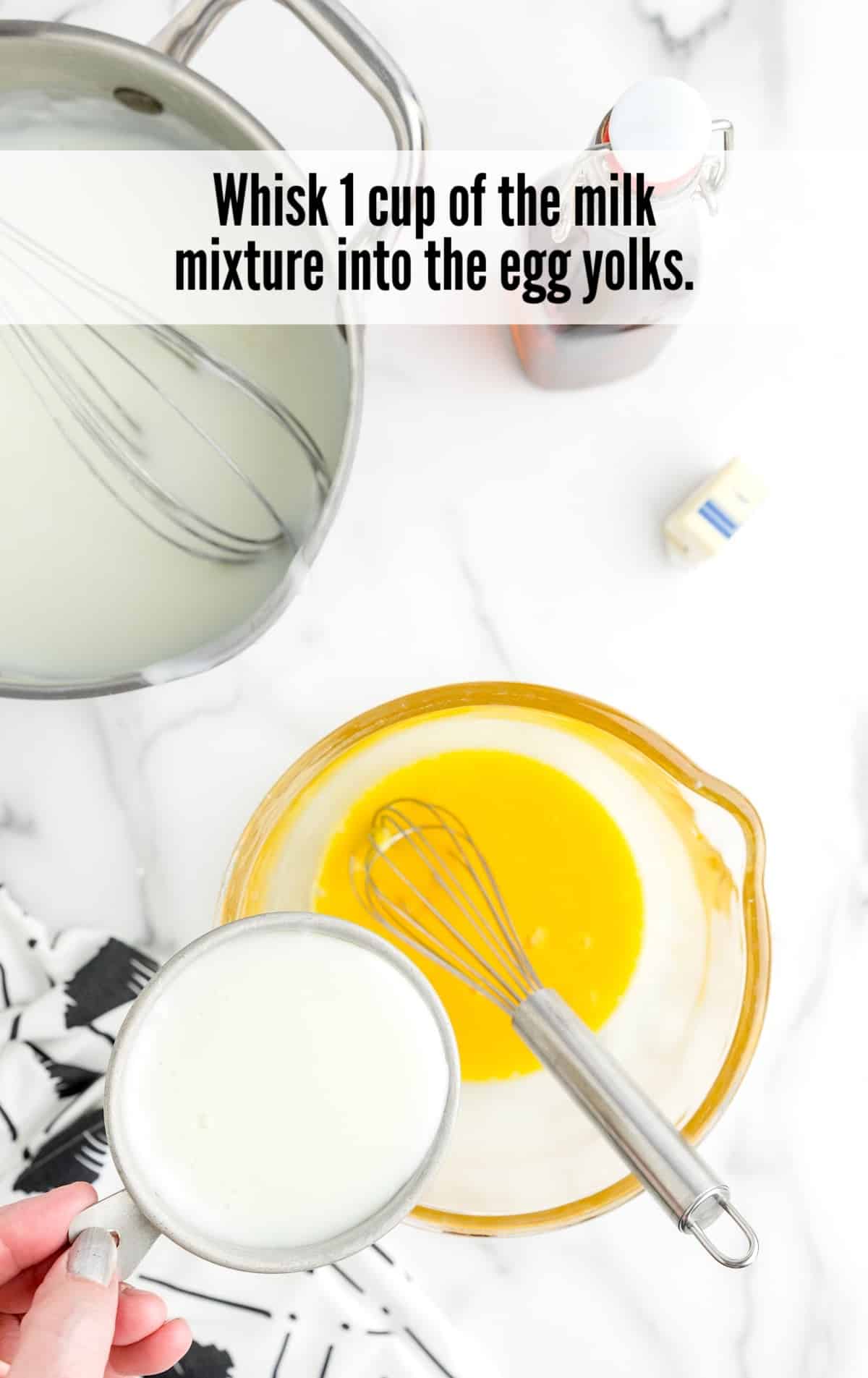 whisking milk and egg yolks in a bowl