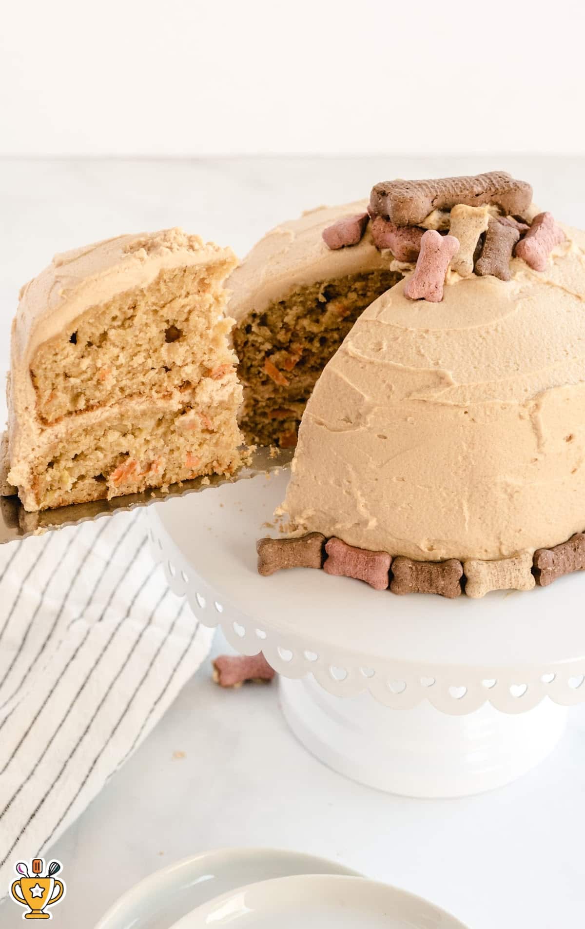 a spatula holding a piece of Dog Birthday Cake and the remaining cake on a cake stand