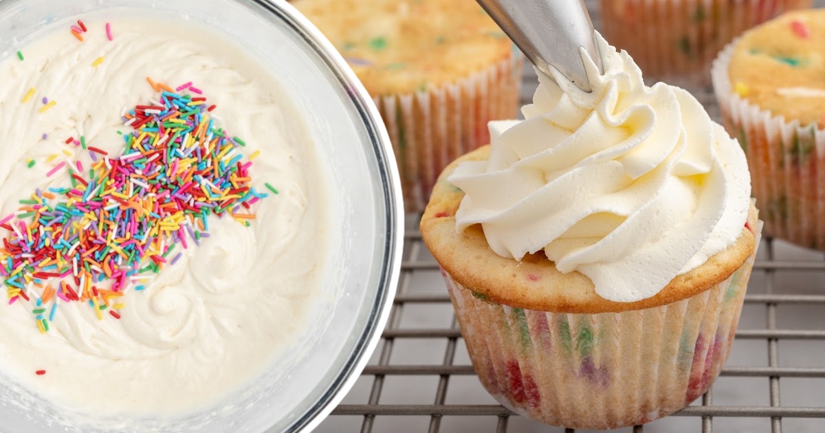 A bowl of frosting and a Funfetti Cupcake being decorated.