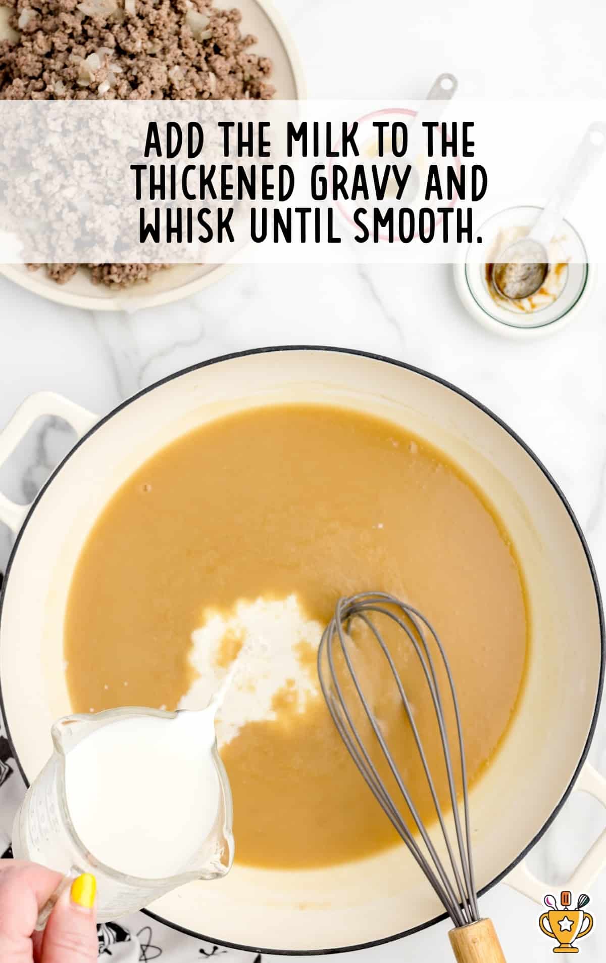 pouring milk to the thickened gravy in a pan