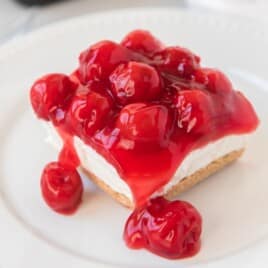 a piece of No Bake Cherry Cheesecake on a white plate