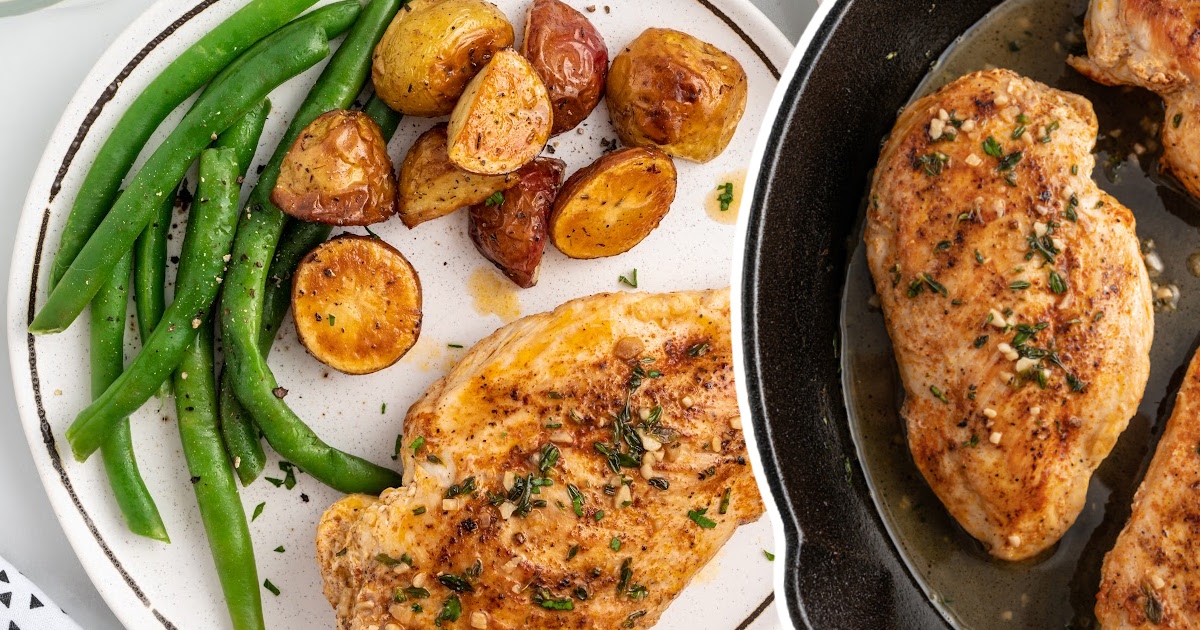 Pan Seared Chicken on a white plate served with potato wedges and green beans
