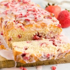 Strawberry Bread with one cut piece on a wooden board