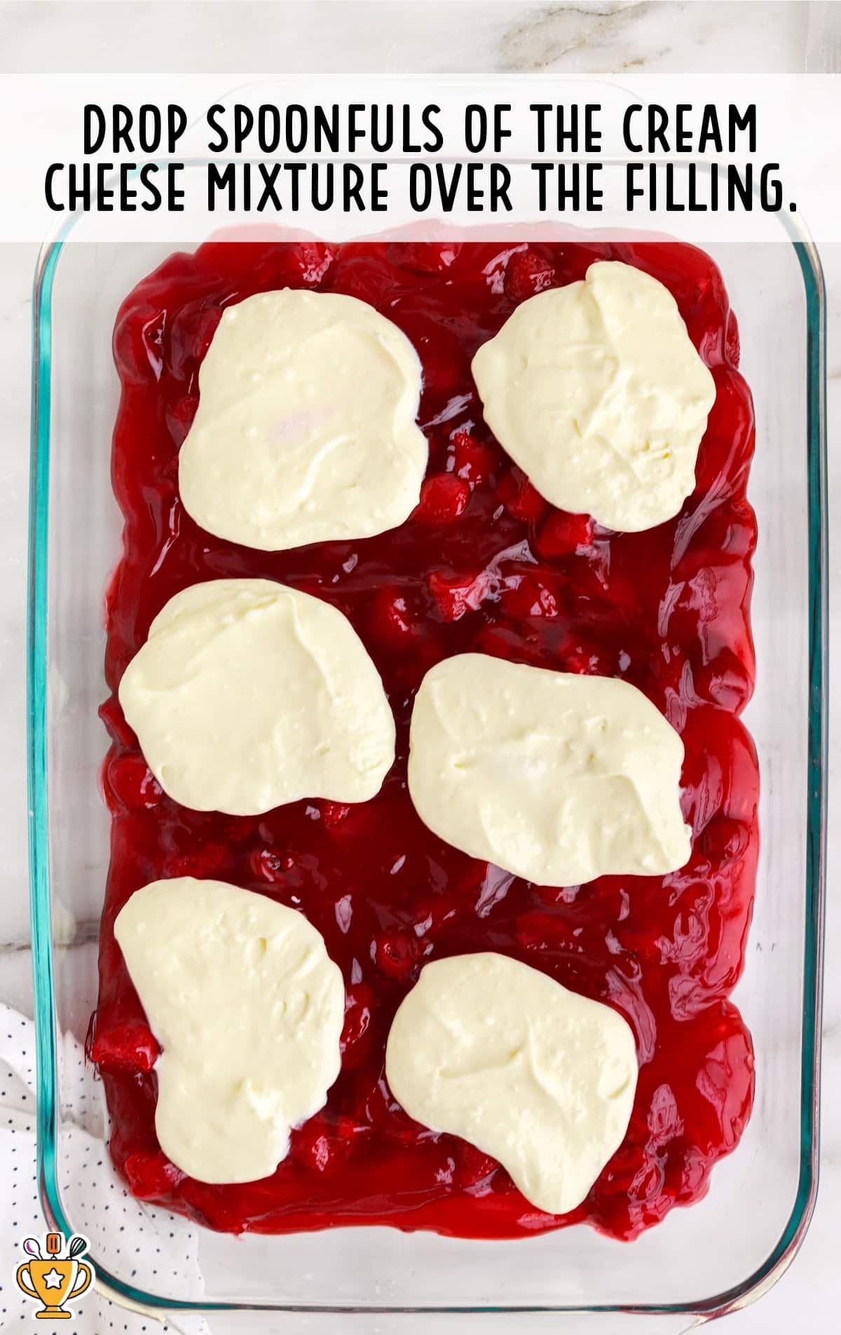 spoonfuls of the cream cheese mixture over the filling in a baking pan