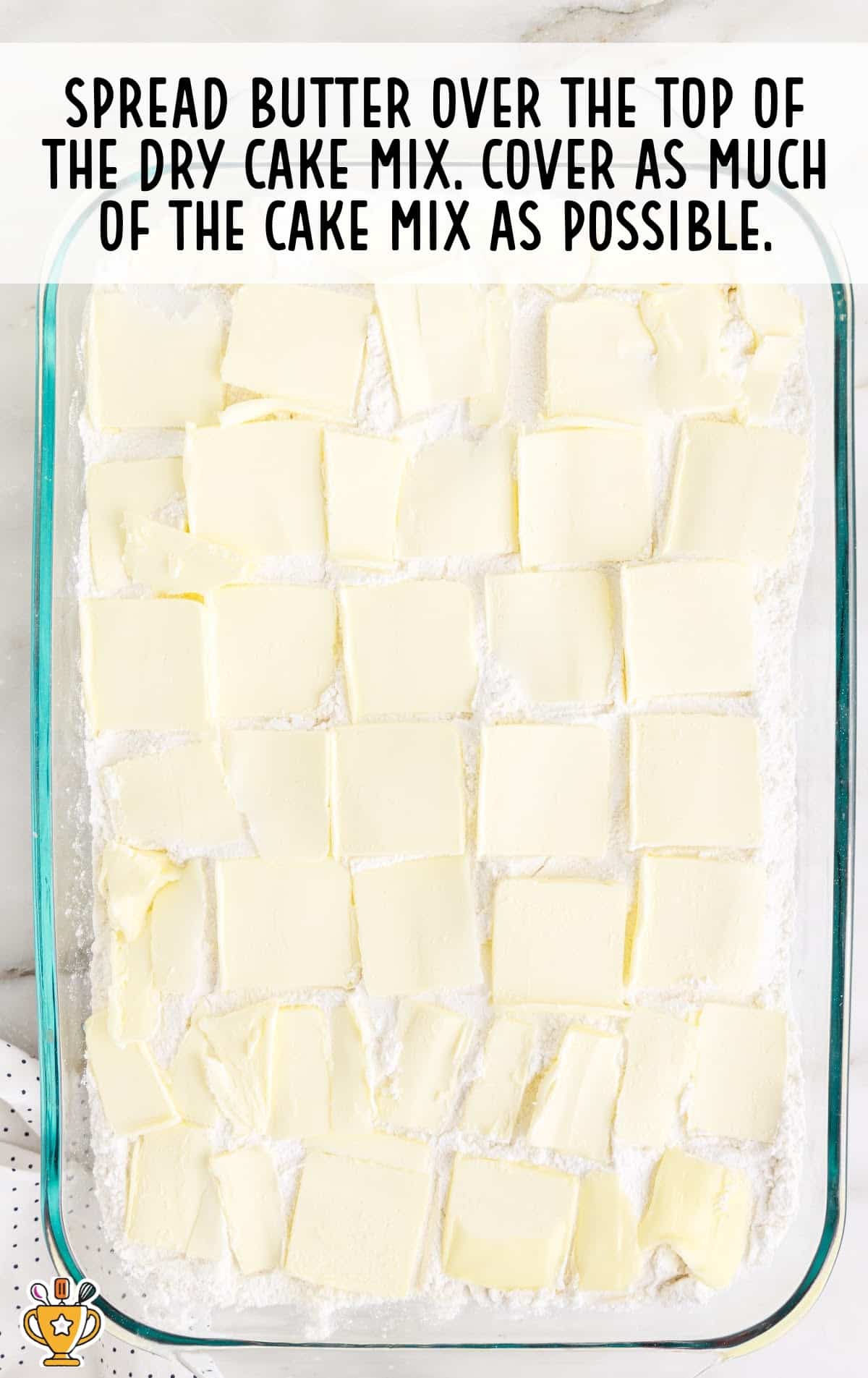 butter spread over the top of the dry cake mix