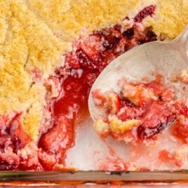 Strawberry Cobbler in a baking dish with a spoon in it