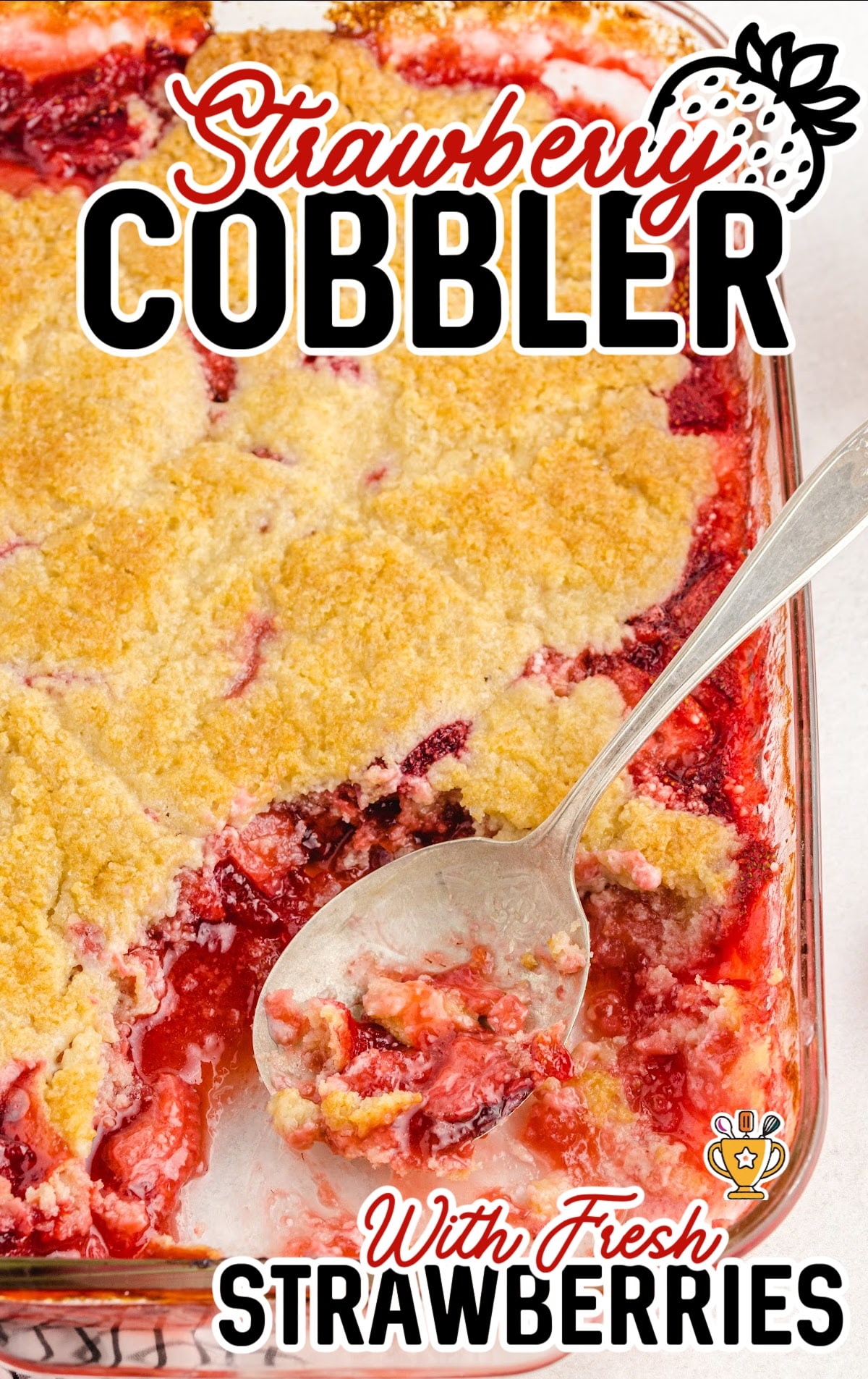 a spoon holding some Strawberry Cobbler and some more in a baking dish