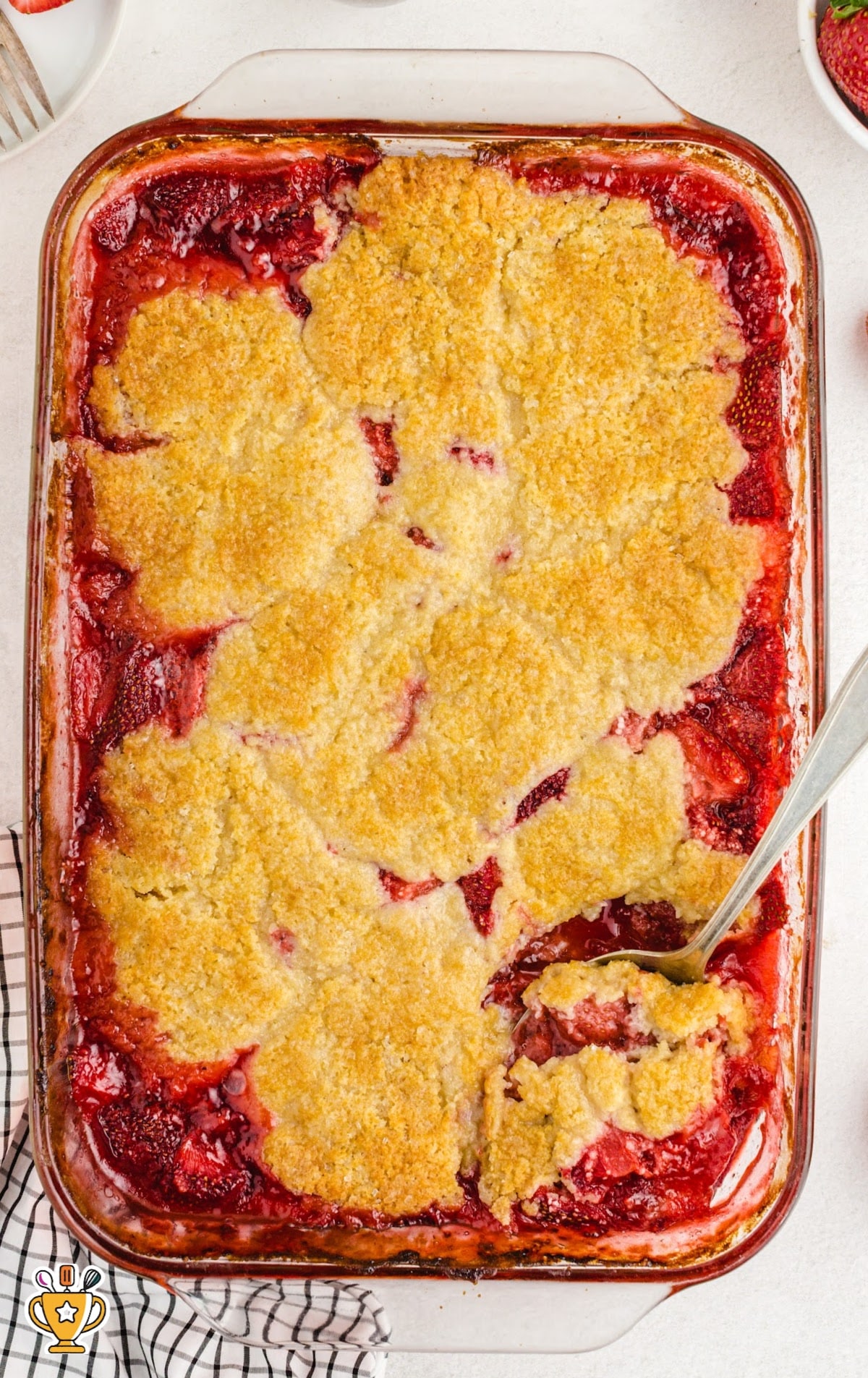 Strawberry Cobbler in a baking dish with a spoon
